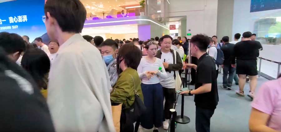 На Пекинском автосалоне 2024, люди стоят в очереди, чтобы увидеть Xiaomi SU7 поближе
