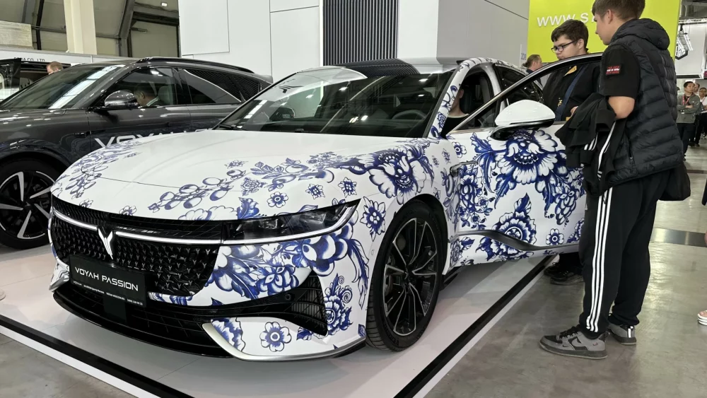 Гибридный седан Voyah Passion EVR на выставке «Иннопром 2025» сбоку спереди гжель