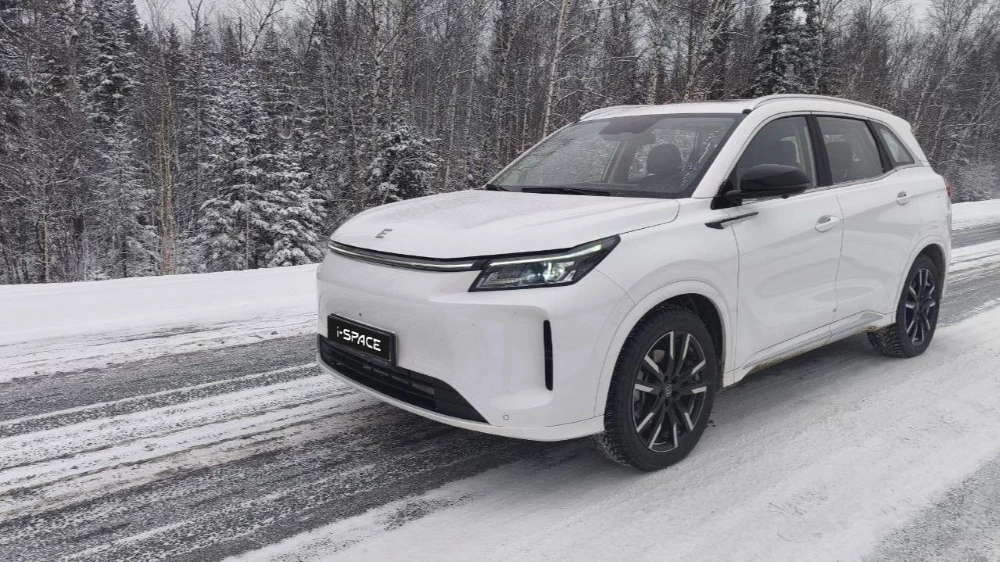 Кроссовер Evolute i-Space полноприводный сбоку спереди зимой на трассе в динамике