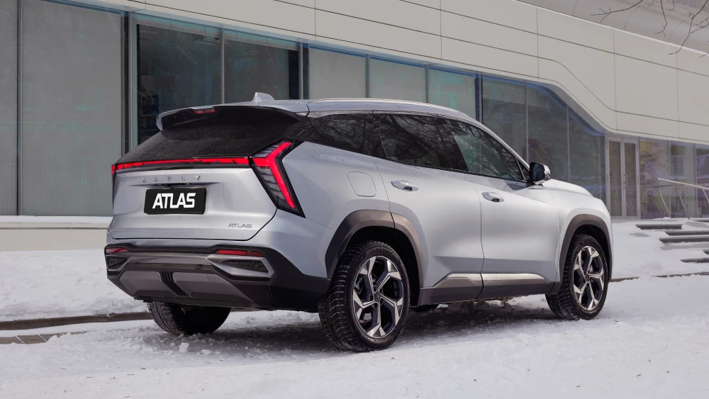 Новая версия кроссовера Geely Atlas с 1,5-литровым мотором сбоку спереди цена luury 2wd